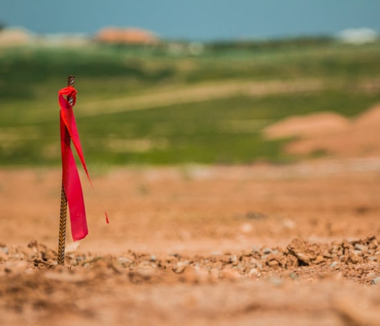 A metal rod in the ground with red fabric attached